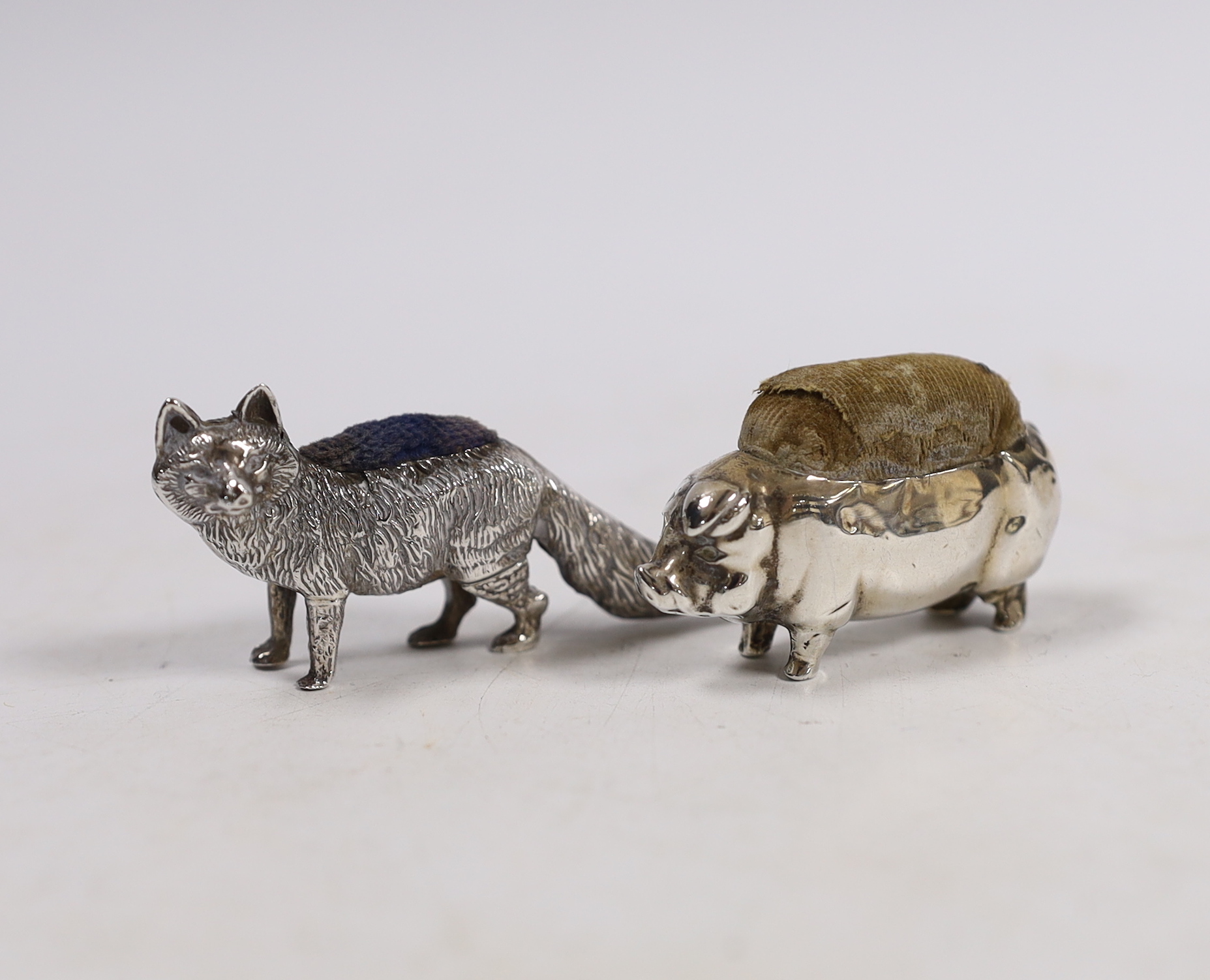 Two early 20th century novelty silver pin cushions, modelled as a fox, Levy & Salaman, Birmingham, 1905, length 60mm and a pig, same maker, marks rubbed.